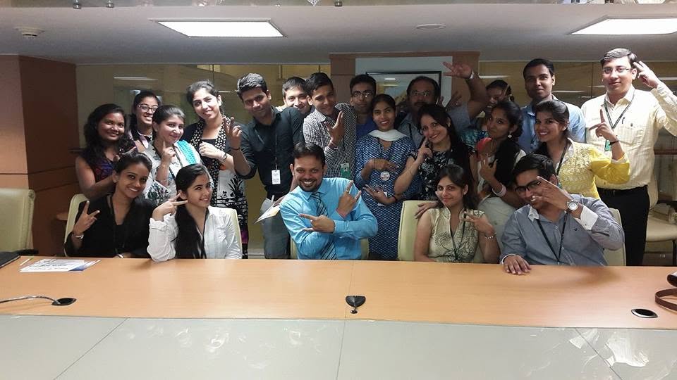 A group of learners and trainers posing around a boardroom table