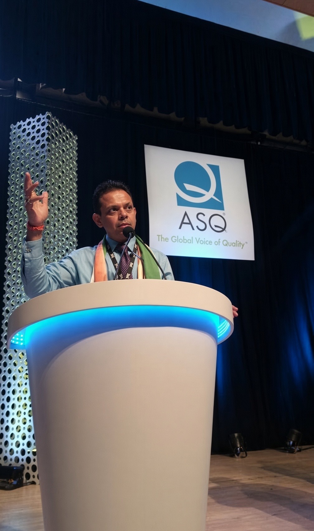 MAGICX founder Pradeep Kumar speaking at a podium beneath the ASQ, The Global Voice of Quality, backdrop