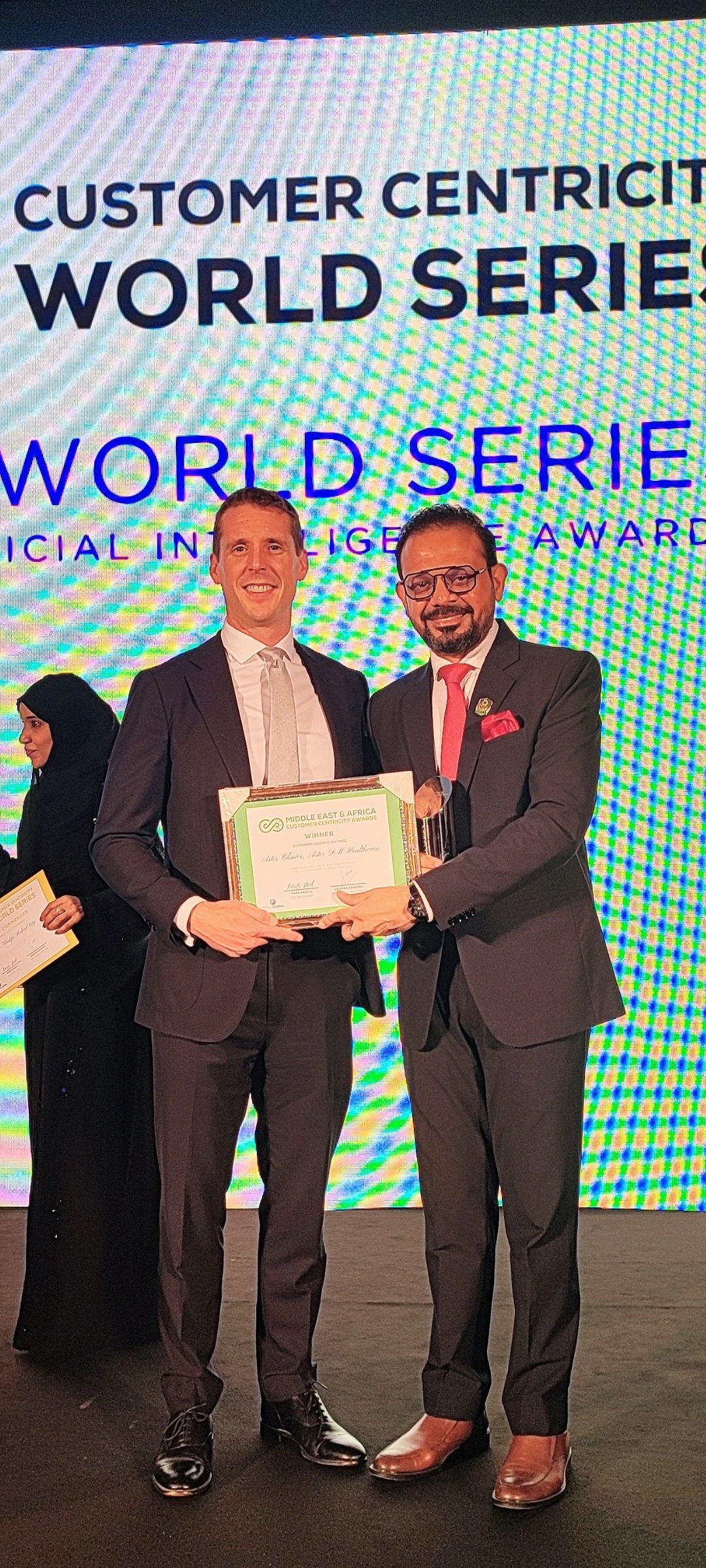 An award certificate being handed over on stage at the Customer Centricity World Series
