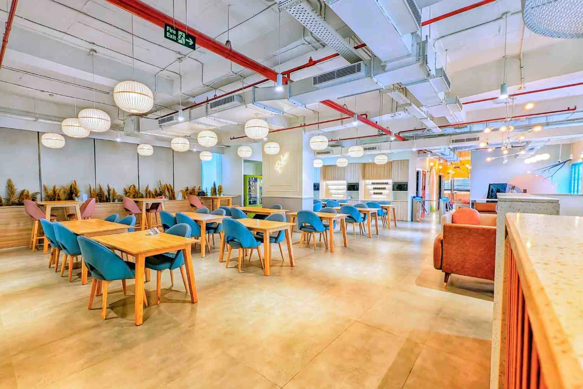 MAGICX cafeteria with wooden tables, blue chairs and pendant lighting